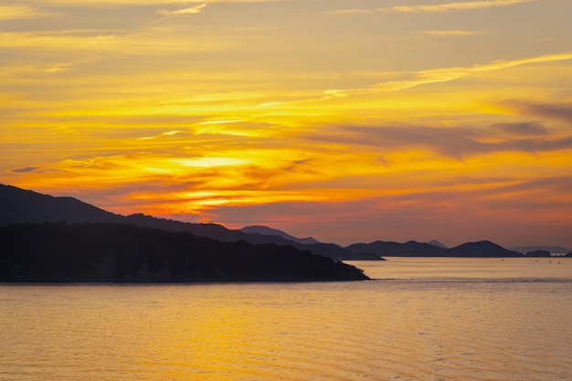 Silhouette island with sunset in colorful light background