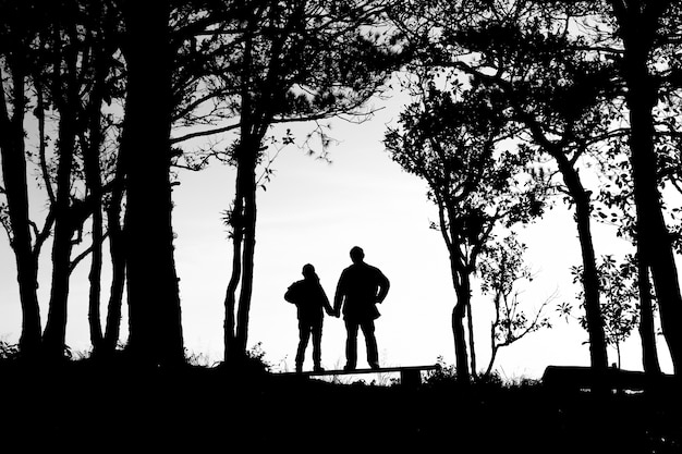 silhouette of love couple in trees border, back and white tone