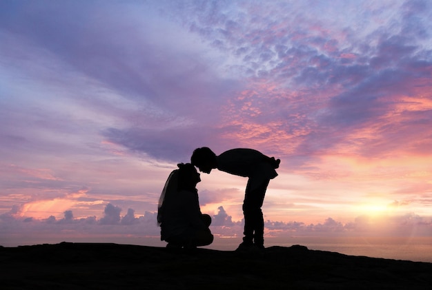 Silhouette of loving couple at sunrise. Love and romance concept.