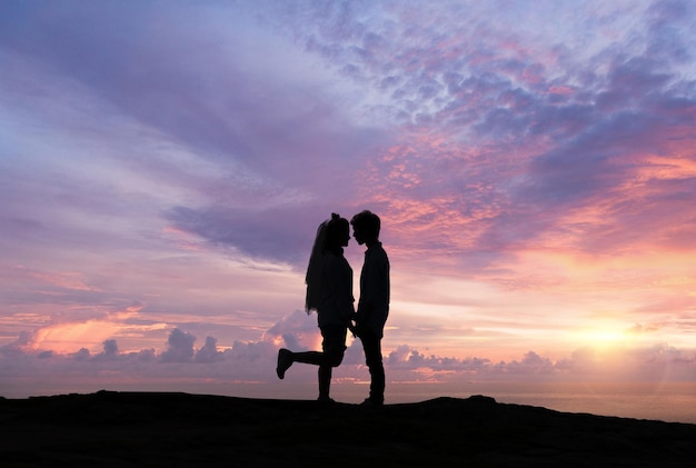 Silhouette of loving couple at sunrise. Love and romance concept.