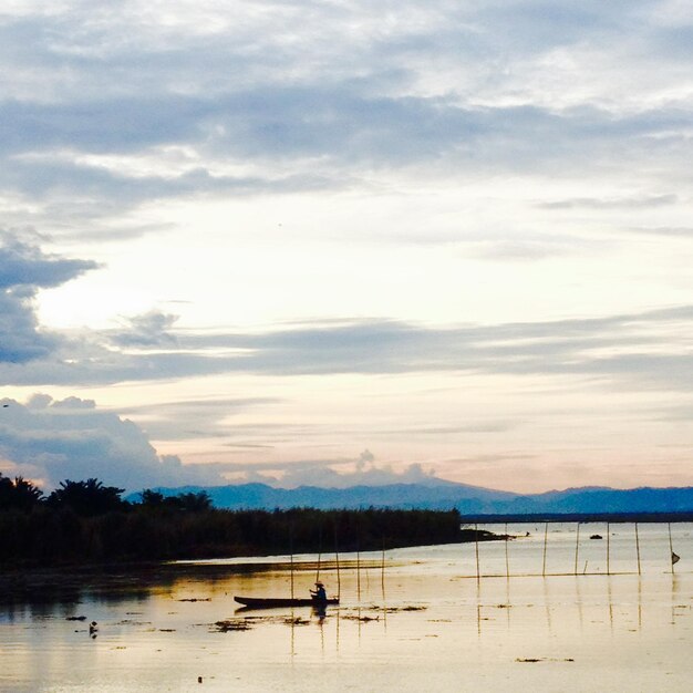 Silhouette of a man fishing in the afternoon. sunset on lake Limboto, Indonesia