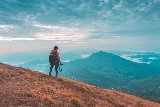 Silhouette of man hold up hands on the peak of mountain,success concept