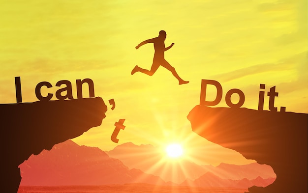 Silhouette of man jumping and change i can't do it to i can do it text on Mountain sky and sun light background Motivation Business success achievement and idea concept