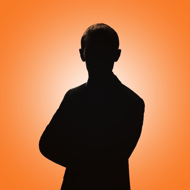 Silhouette of a man Man posing in a suit on an orange background