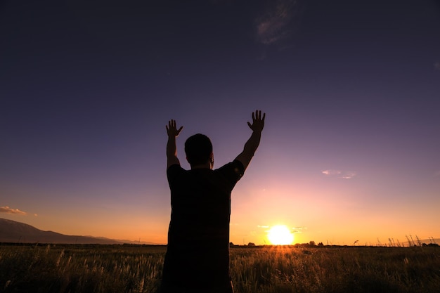 Silhouette man show his hands up