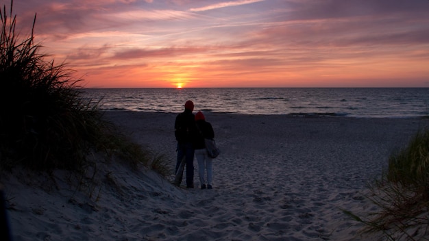 Silhouette man standing on beach against sky during sunset