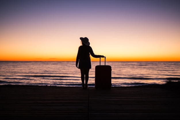 Silhouette man standing on beach against sky during sunset