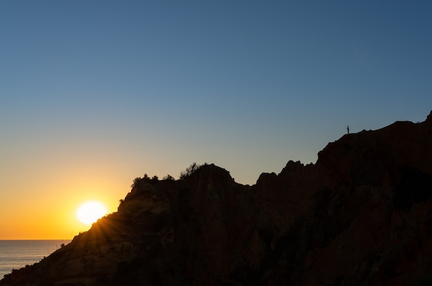 Silhouette of a man taking a photo at sunrise