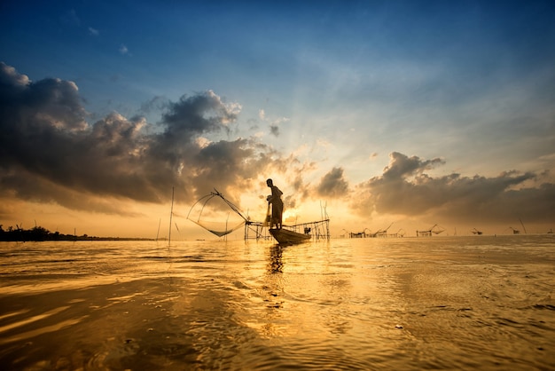 Silhouette of man with fish nets in morning at Pakpra, Phatthalung, Thailand