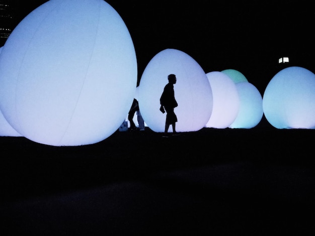 a silhouette of a man and a woman walking in the dark