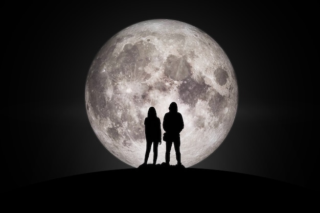 Silhouette of man and women  Looking at the moon in love Elements of this image furnished by NASA