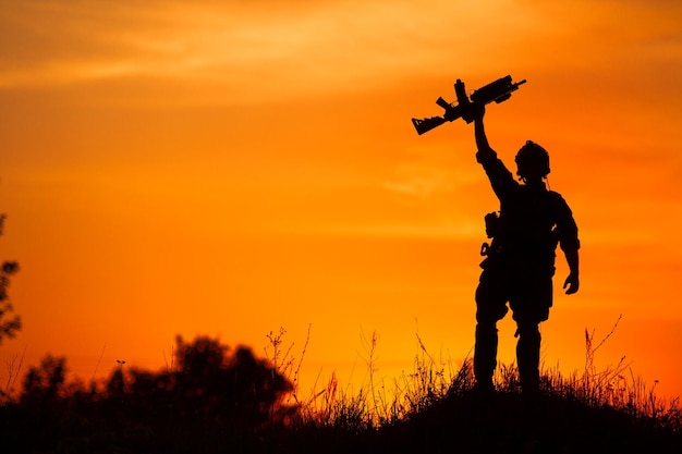 Silhouette of military soldier or officer with weapons at sunset