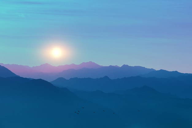 Silhouette of mountain ranges against the sunset sky