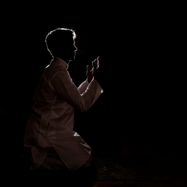 Silhouette of muslim man praying