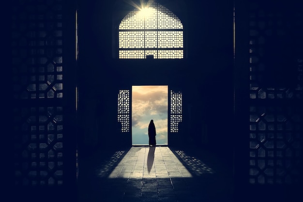 Silhouette of a Muslim woman in a hijab on the background of traditional architecture and sunset Iran