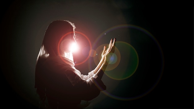 Silhouette of muslim woman praying