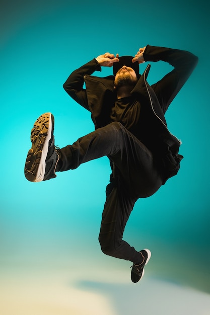 Photo the silhouette of one young hip hop male break dancer dancing on colorful background