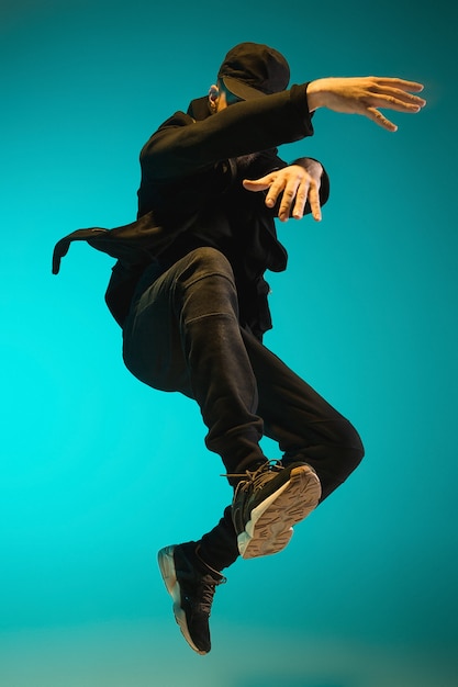 Photo the silhouette of one young hip hop male break dancer dancing on colorful background