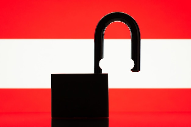 Silhouette of open lock against flag of Austria