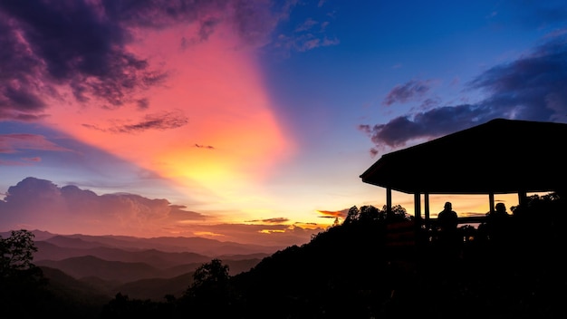 Silhouette of pavilion at mountain view point in sunset sky with clouds