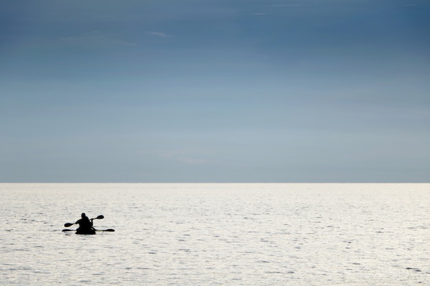 Silhouette people boating canoe boat in sea on vacation time for relax at Teay Ngam Beach