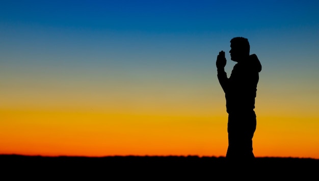 Silhouette of a person on the background of a yellowblue sky