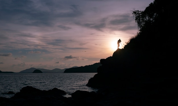 Silhouette of a photographer or traveler using a professional DSLR camera