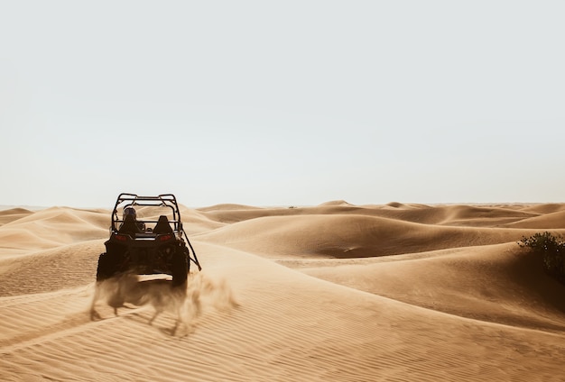 Silhouette of quad buggy bike drifting at safari sand dunes of Al Awir desert, Dubai, UAE