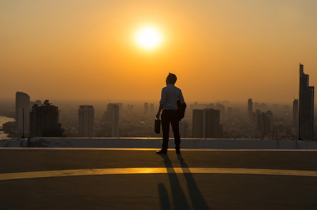 Silhouette Rear view of businessman standing with carrying the business bag