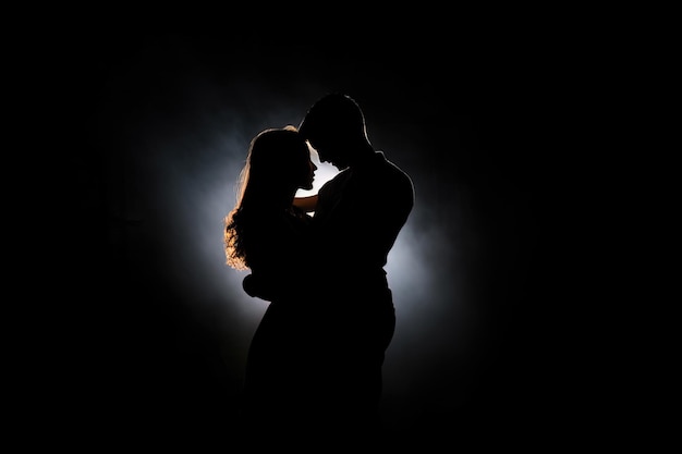 Silhouette of a romantic couple dancing and enjoying in the dark