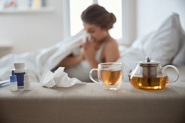 Silhouette of sick woman that wiping her nose while staying in bed