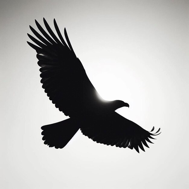 Photo a silhouette of a soaring eagle with wings fully spread gliding effortlessly across a clear white ba