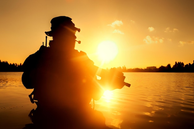 Silhouette of special forces with rifle in action during river raid in the jungle waist deep in the water. Proflie side view, half length