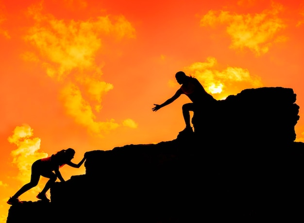 Silhouette Sporty woman climbing on the cliff. Business Teamwork Success and goal concept