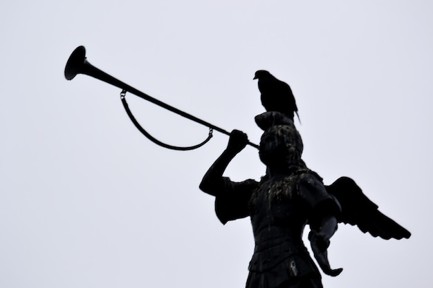 Silhouette of a statue with a trumpet