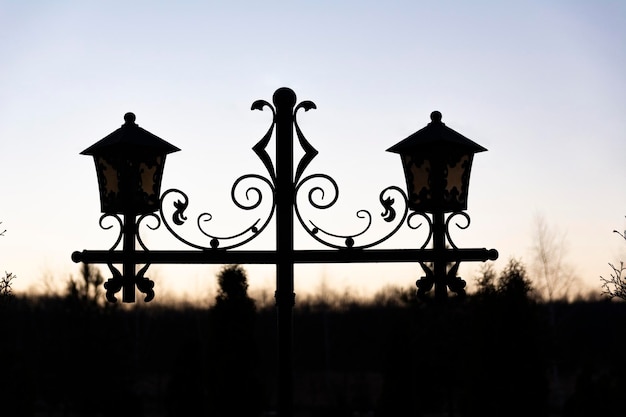 Silhouette of a street vintage twin lantern with forged twisted elements isolated