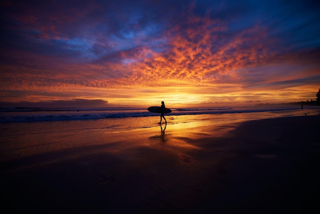 Silhouette of surfer in the background of vibrant sunset scenery Nosara peninsula Costa Rica