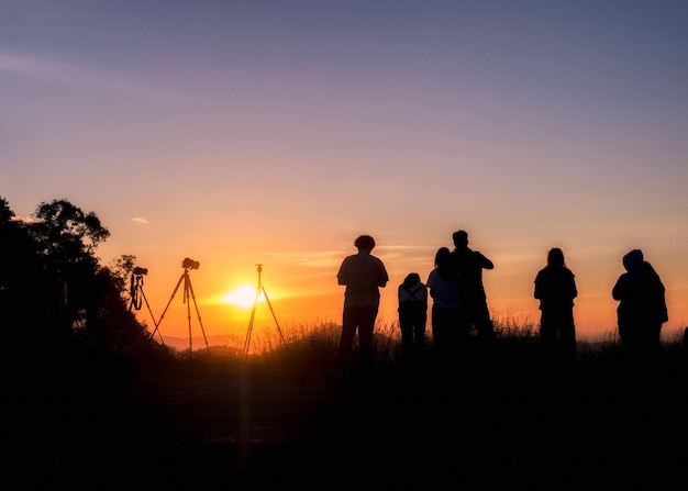 Silhouette tourists stand looking view at sunset