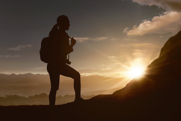 Silhouette of traveler woman hiking the mountain