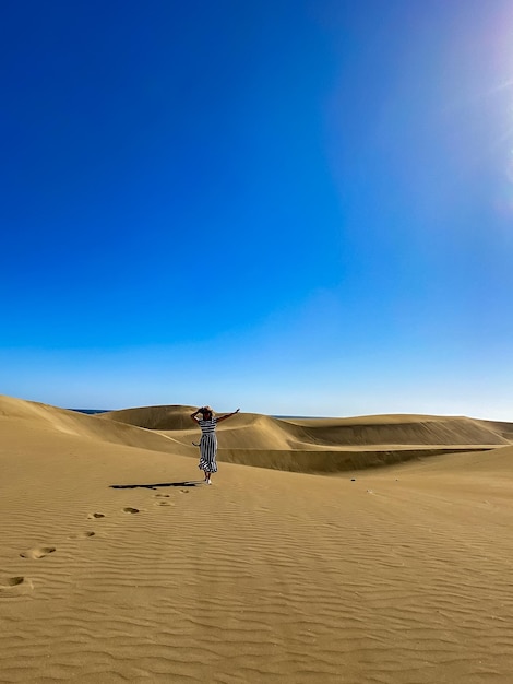 Silhouette of a woman in the desert, footprints in the sand