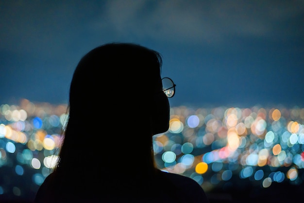 Silhouette Woman portrait  in city night light bokeh  , Chiang mai ,Thailand