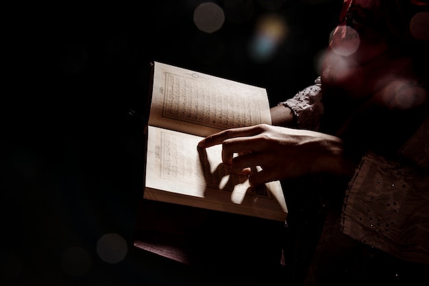 Silhouette of woman reading in quran