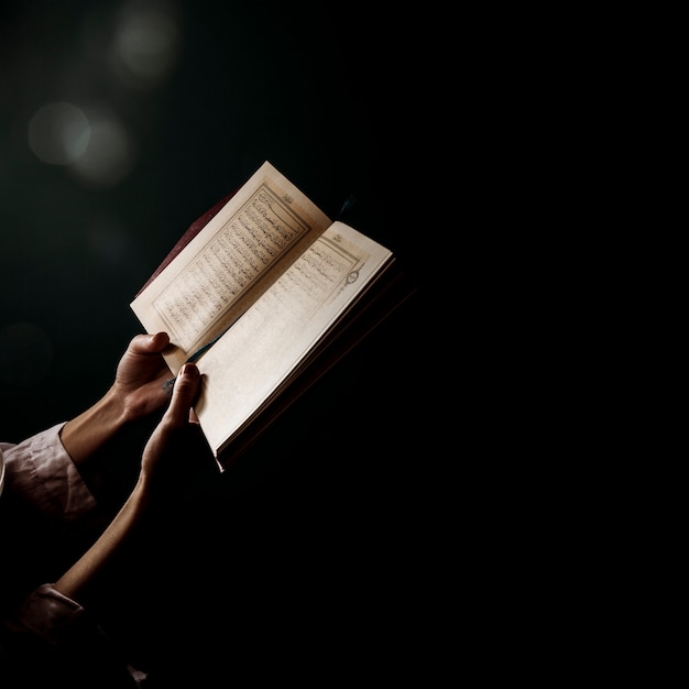 Silhouette of woman reading in quran