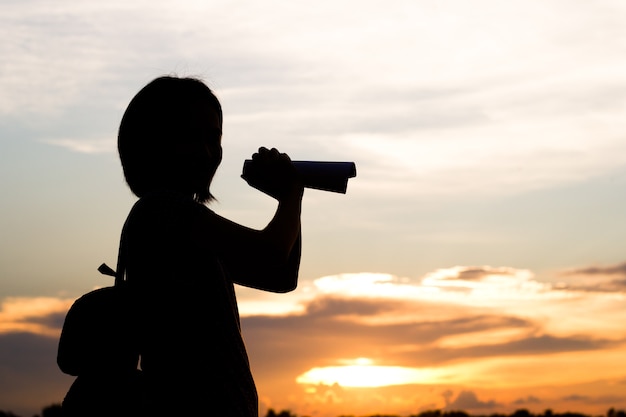 Silhouette of woman use binocular to view long distance subject.