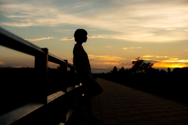 Silhouette woman with sadness at sunset alone.