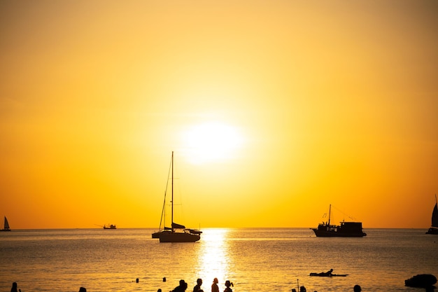 Silhouette Yacht boat sailing boats or Travel boats in Beautiful phuket sea at sunset golden sky Amazing for summer holiday background and Travel destination or Website Beautiful phuket island