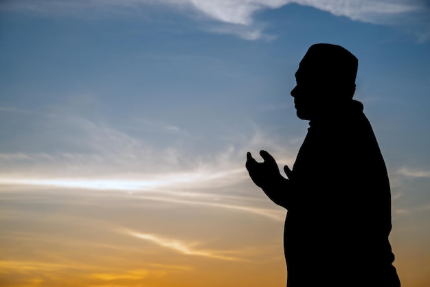 Silhouette Young asian muslim man praying on sunsetRamadan festival concept