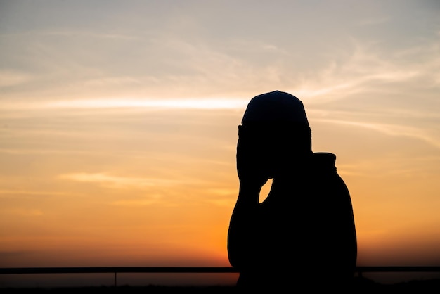 Silhouette Young asian muslim man praying on sunsetRamadan festival concept