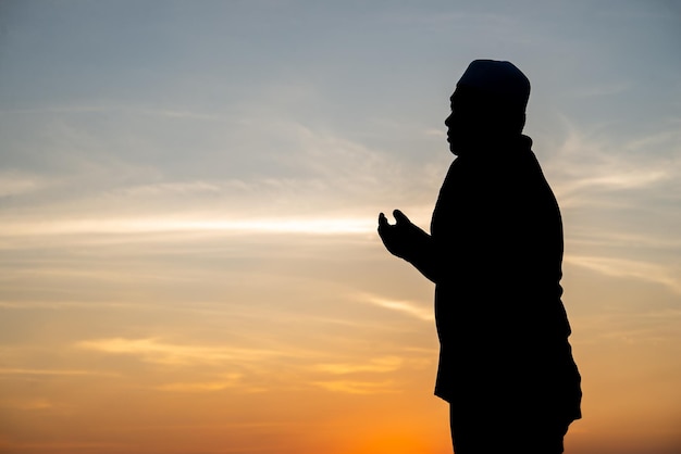 Silhouette Young asian muslim man praying on sunsetRamadan festival concept