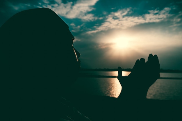 Silhouette Young asian muslim man praying on sunsetRamadan festival concept